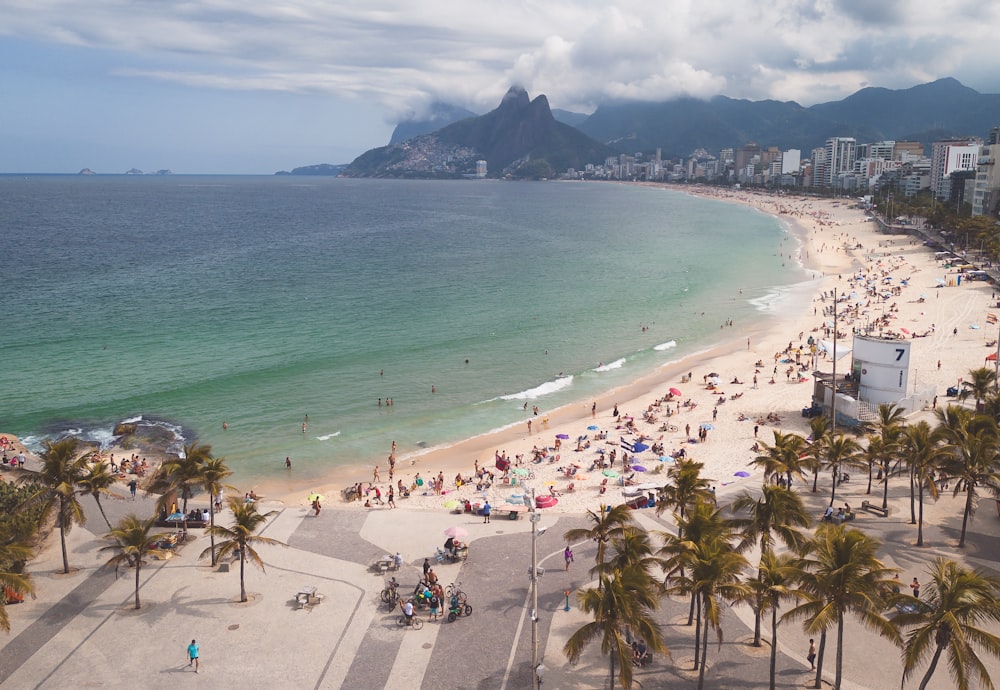 a crowded beach with a mountain in the background