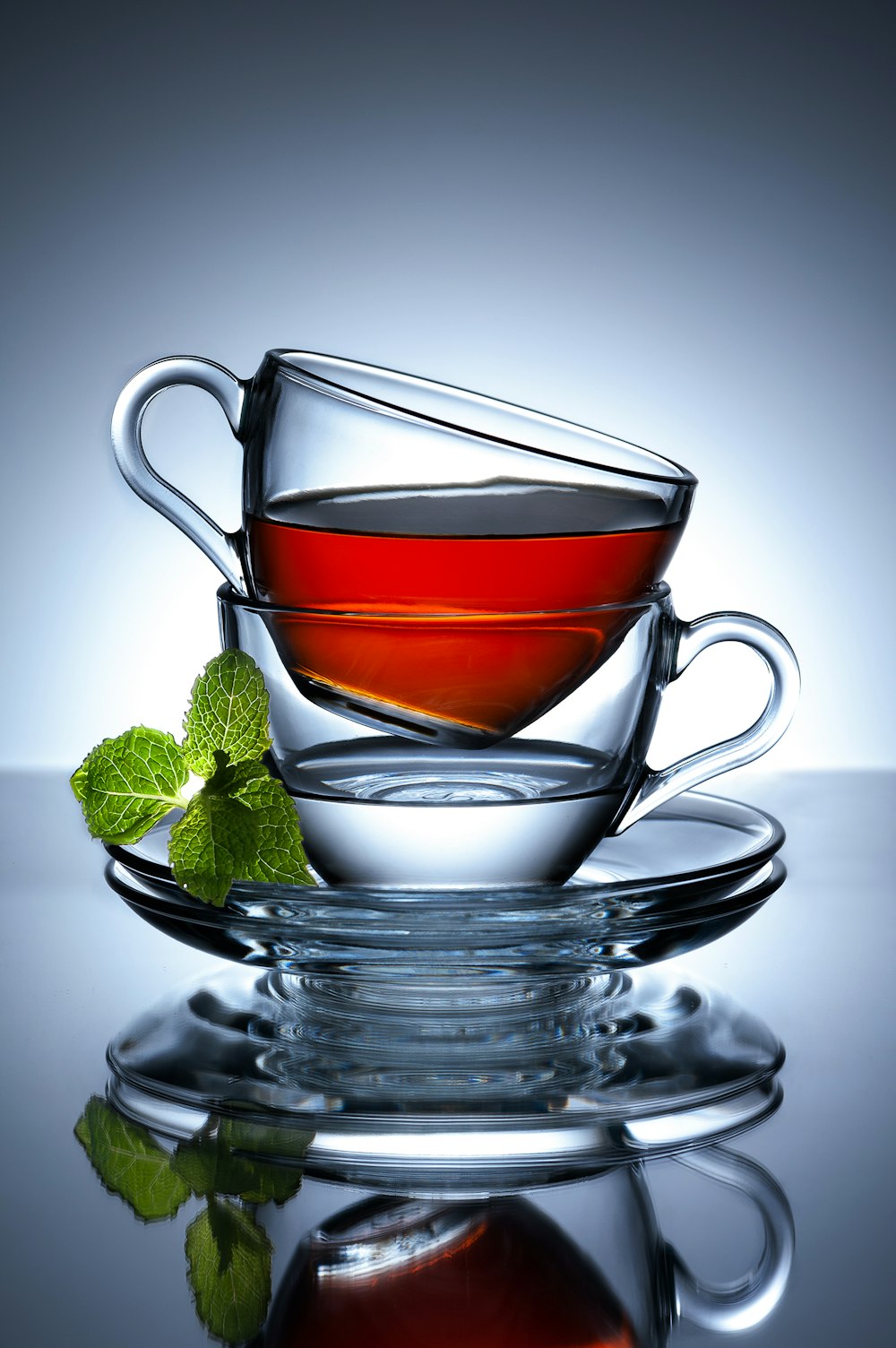 a cup of tea with a mint on a reflective surface