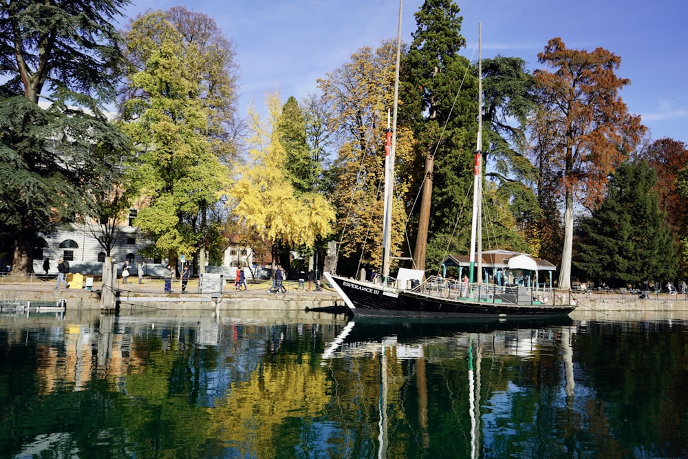 a boat is sitting on the water near a dock