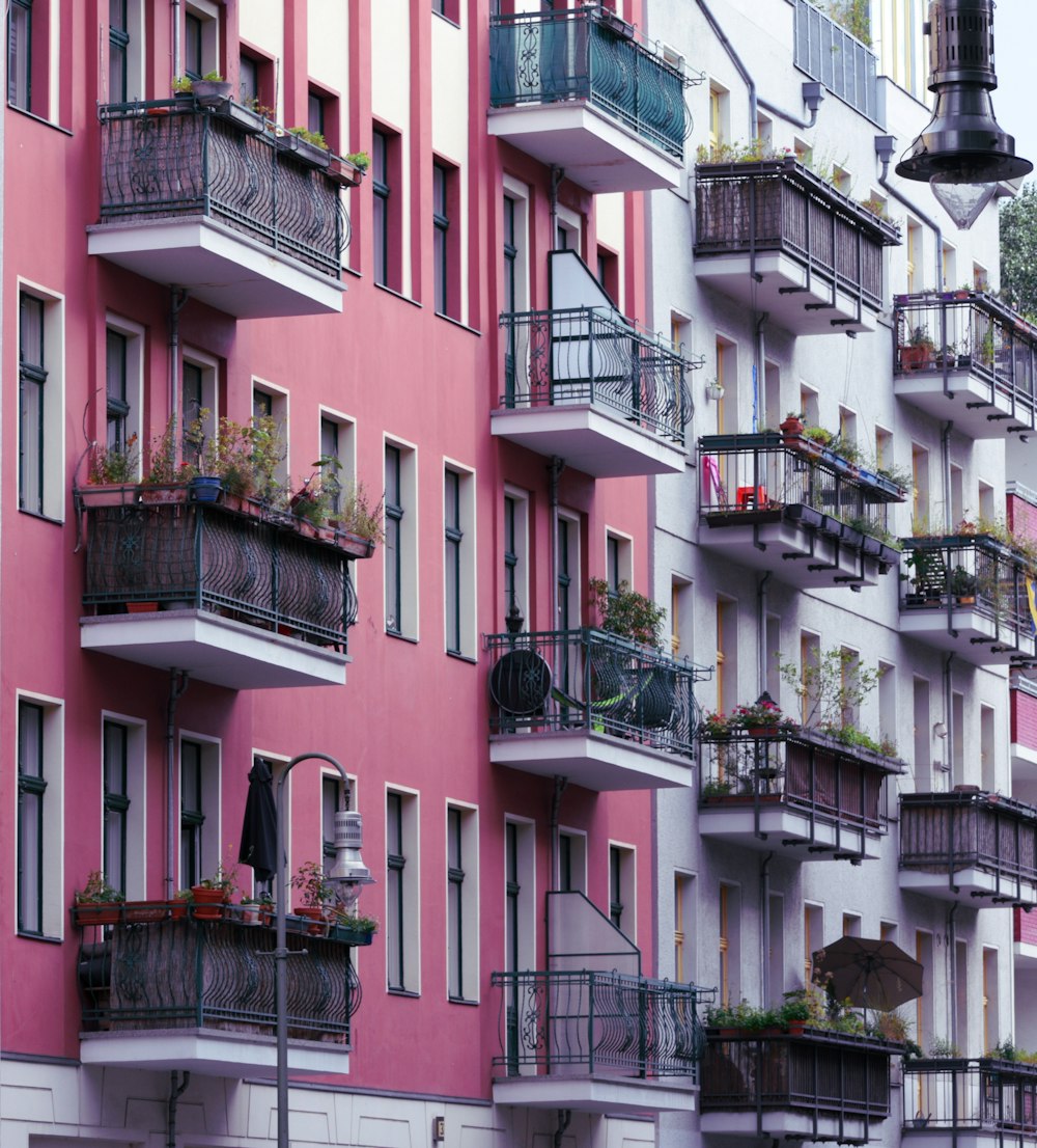 a tall building with balconies and plants on the balconies