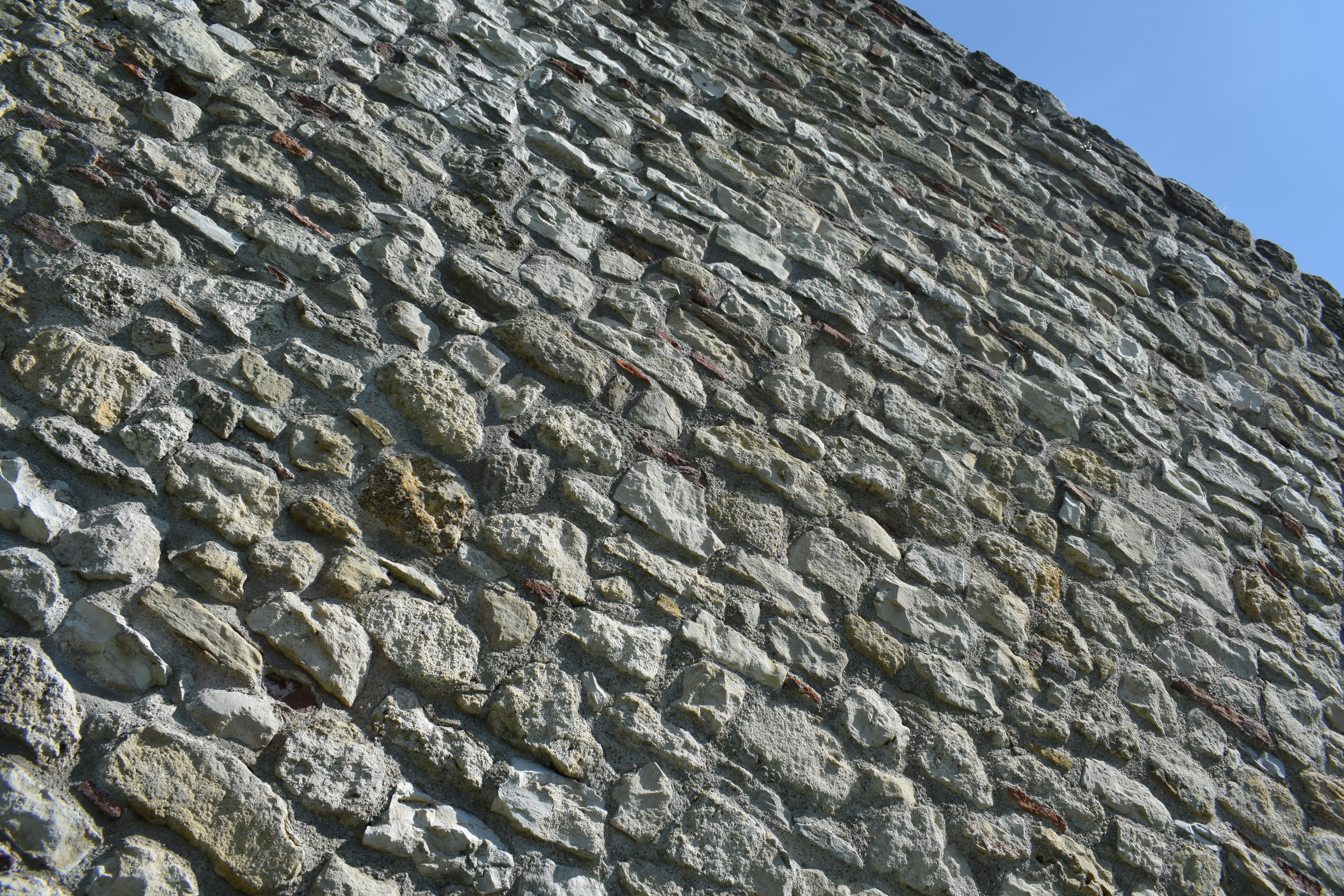 a stone wall with a clock on top of it