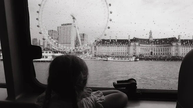a little girl looking out a window at a ferris wheel
