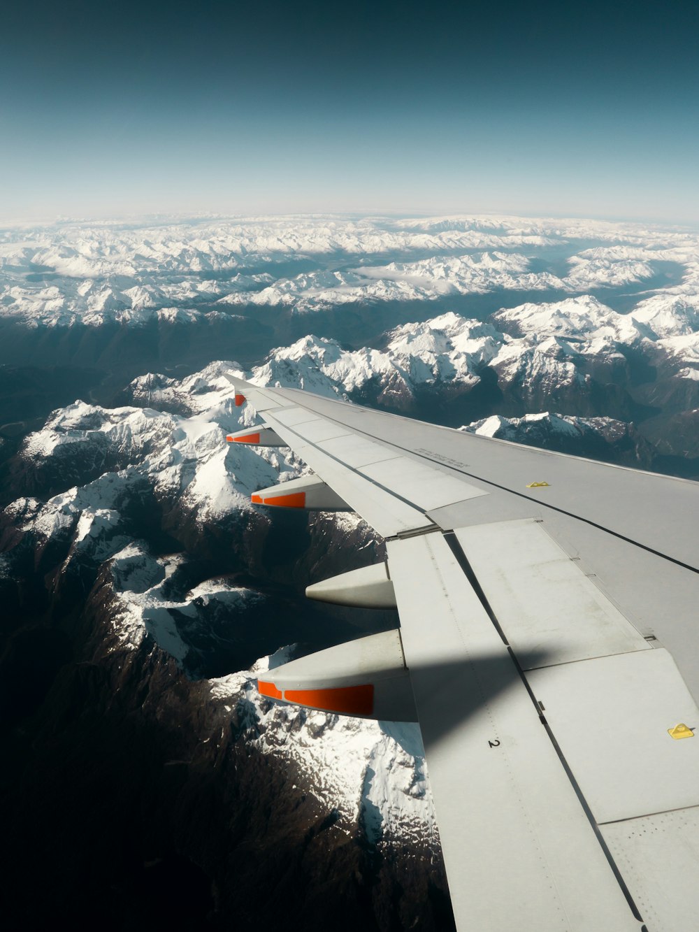 the wing of an airplane flying over a mountain range