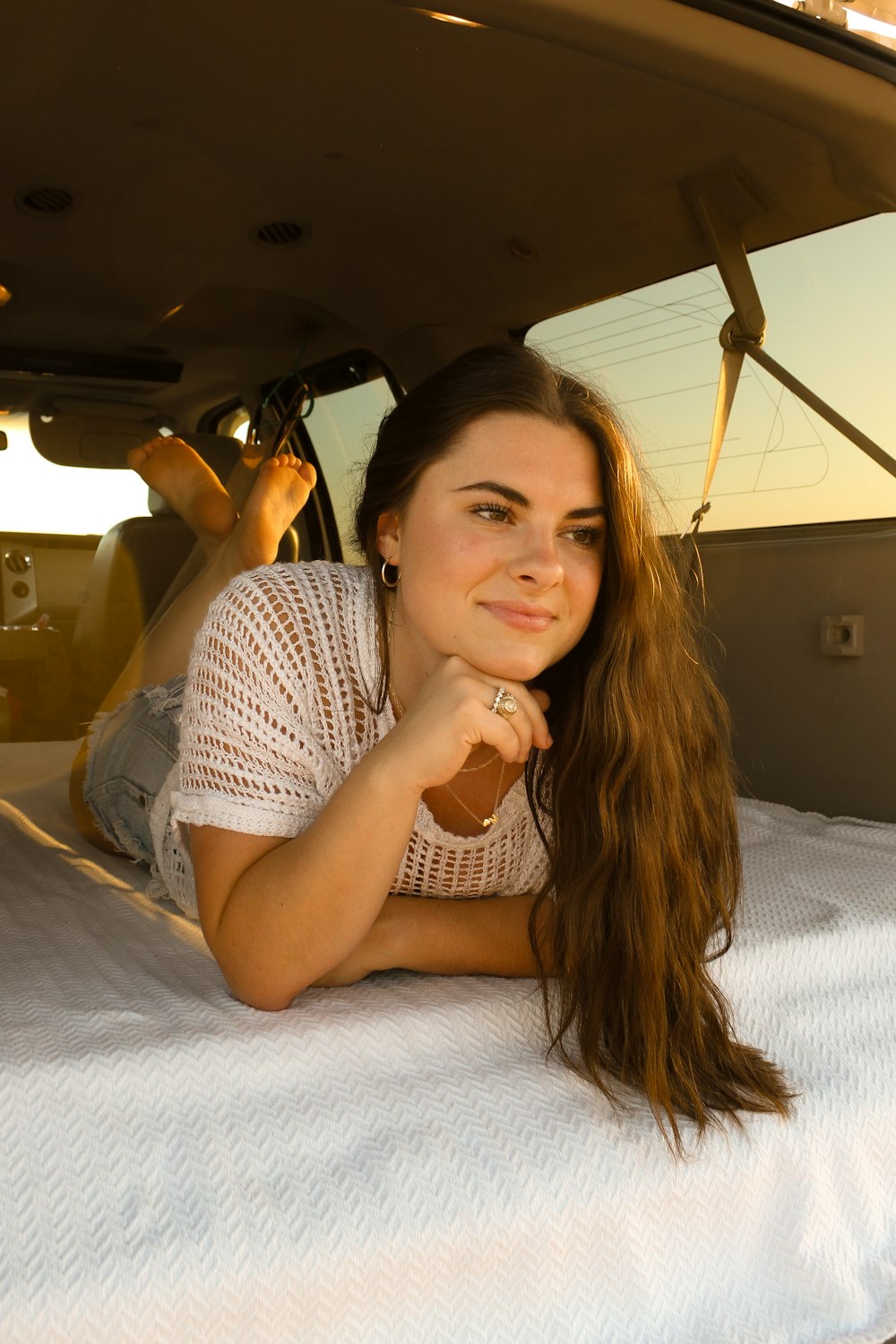 a woman laying on top of a bed next to an airplane