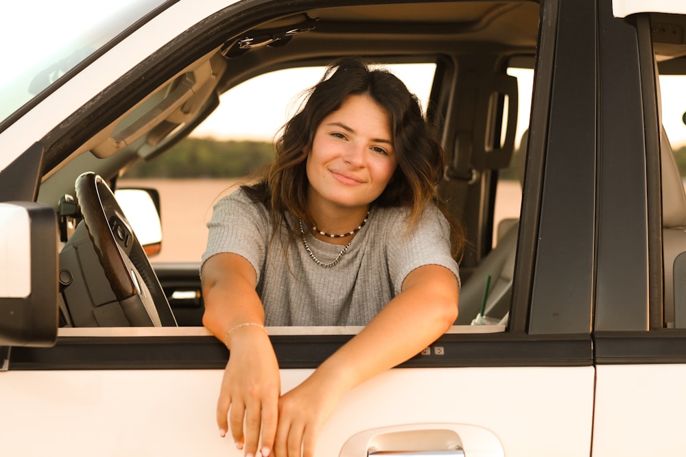 a woman sitting in the drivers seat of a truck