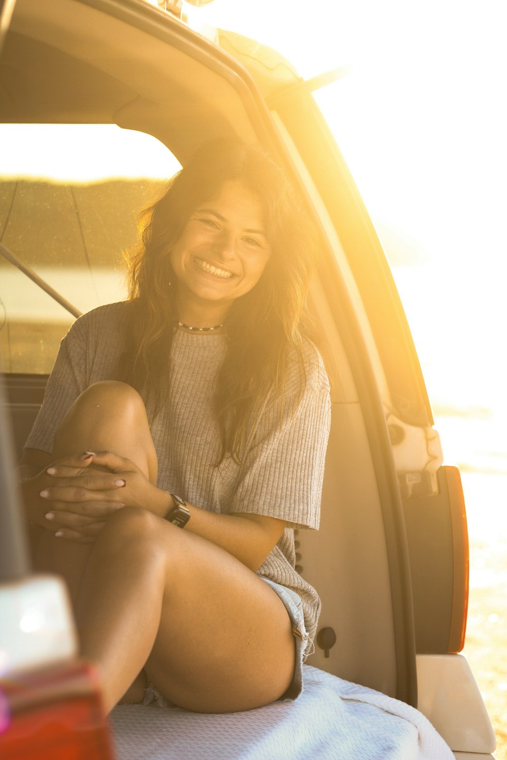 a smiling woman sitting in the back of a car