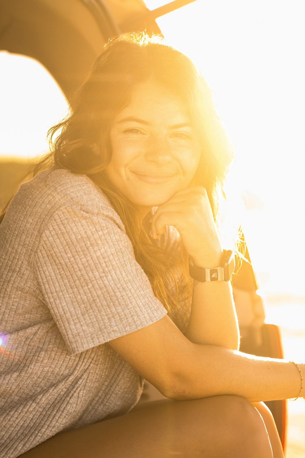 a smiling woman sitting in the back of a truck