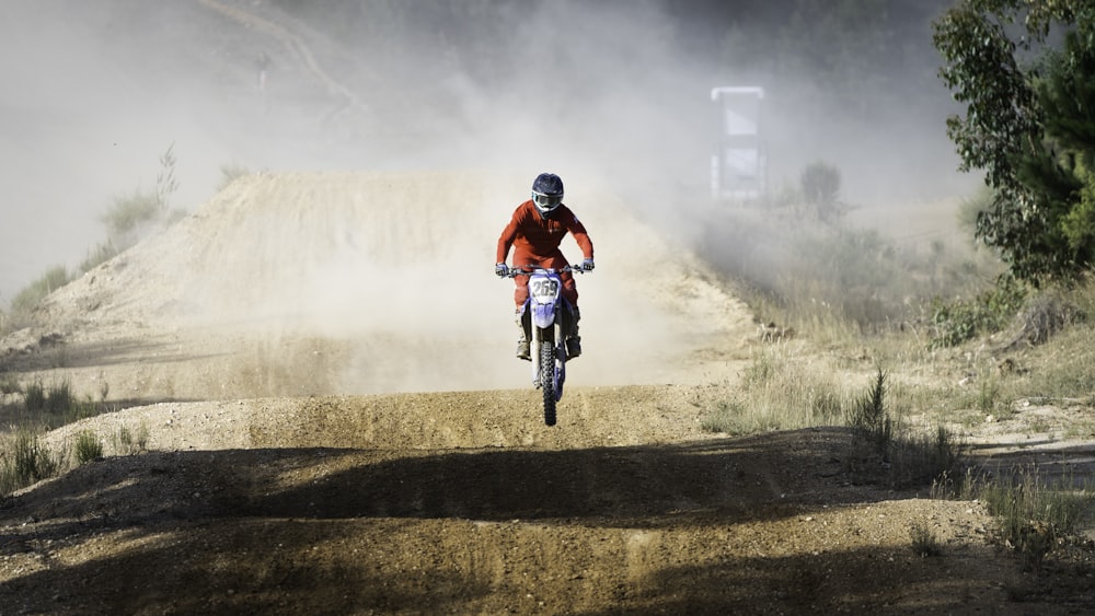 a man riding a bike down a dirt road