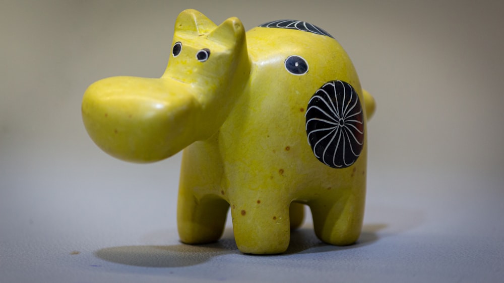 a yellow elephant figurine sitting on top of a table