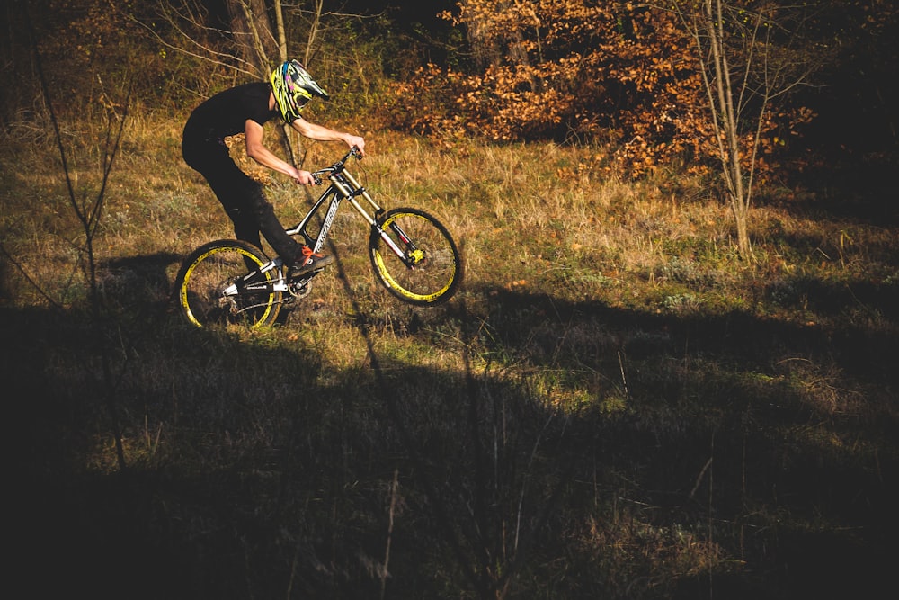 a man riding a bike through a lush green forest