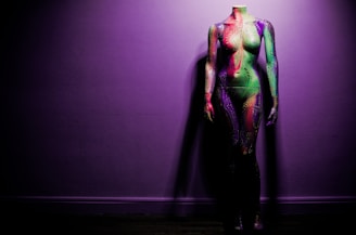 A stylish mannequin dressed in elegant innerwear with a neon purple background.