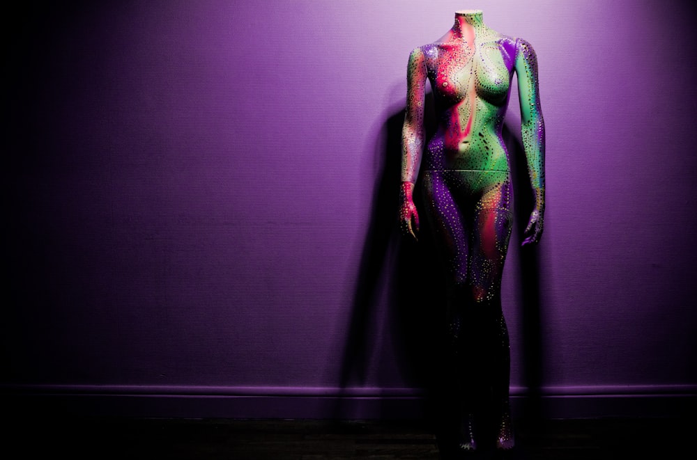 a woman's body is covered in multicolored paint