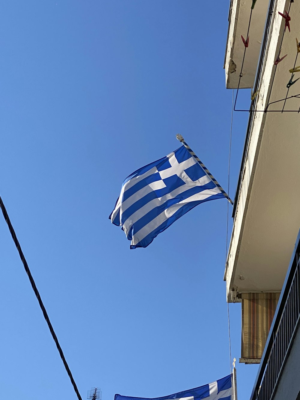 Una bandera griega ondeando frente a un edificio