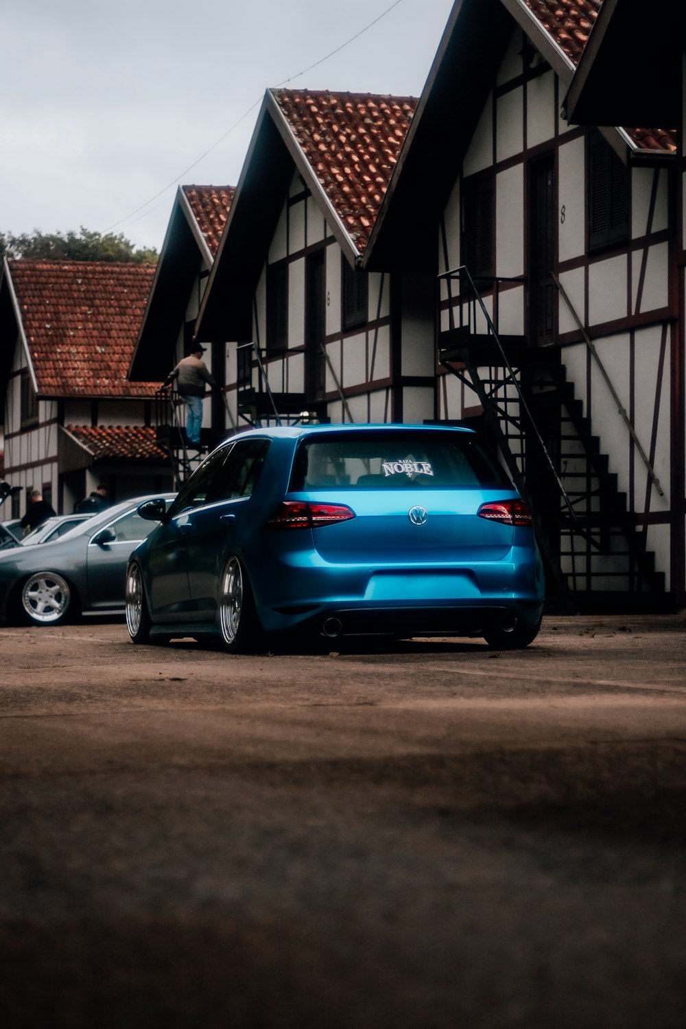 a blue car parked in front of a building