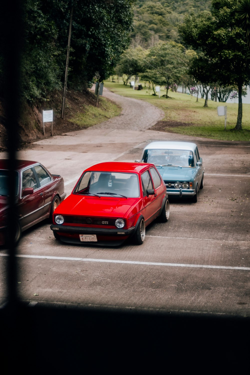 three cars are parked in a parking lot