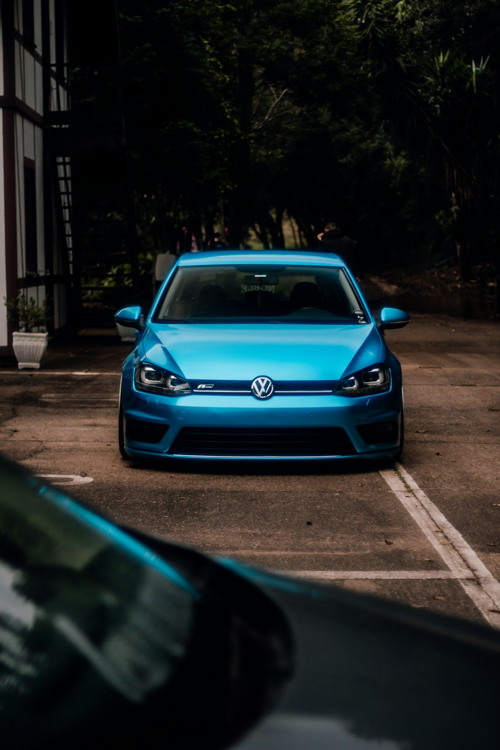 a blue volkswagen car parked in a parking lot