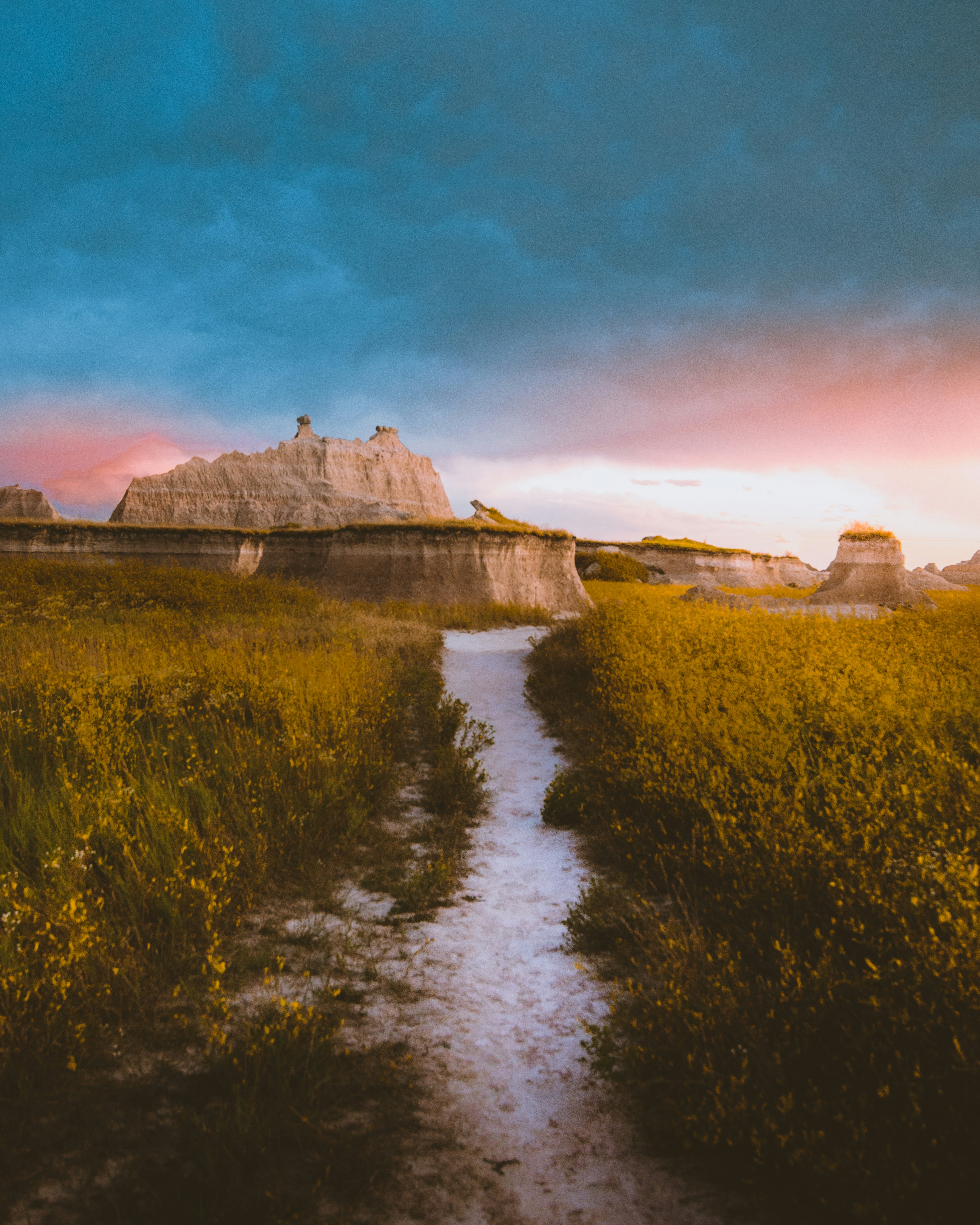 a dirt path leading to a large rock formation
