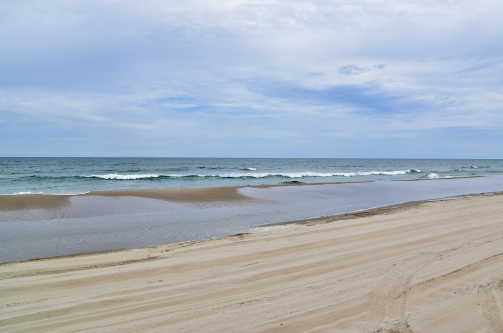 a large body of water sitting next to a sandy beach