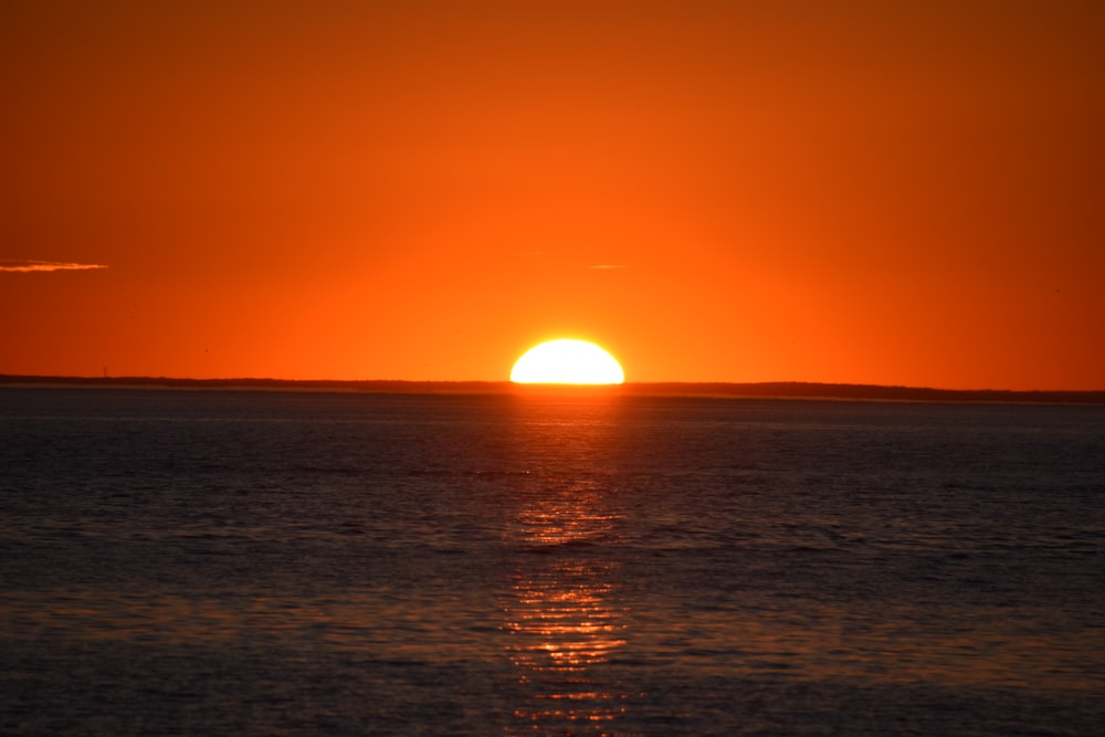 the sun is setting over the ocean on a clear day