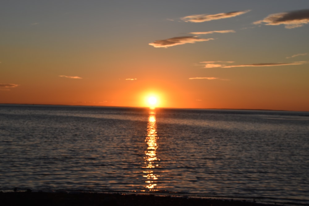 the sun is setting over the ocean on a clear day