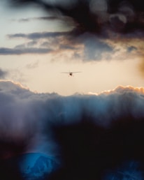 A private jet soaring above the clouds at sunset, embodying luxury travel.