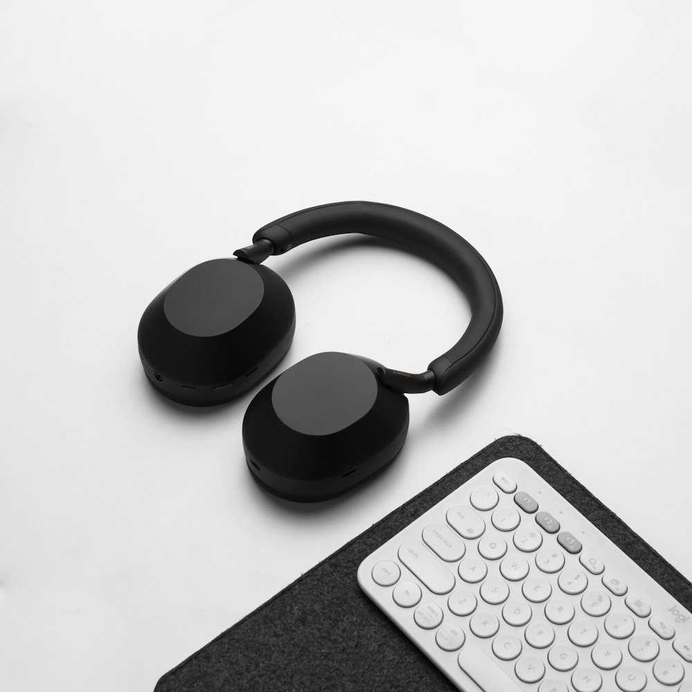 a pair of headphones sitting next to a keyboard