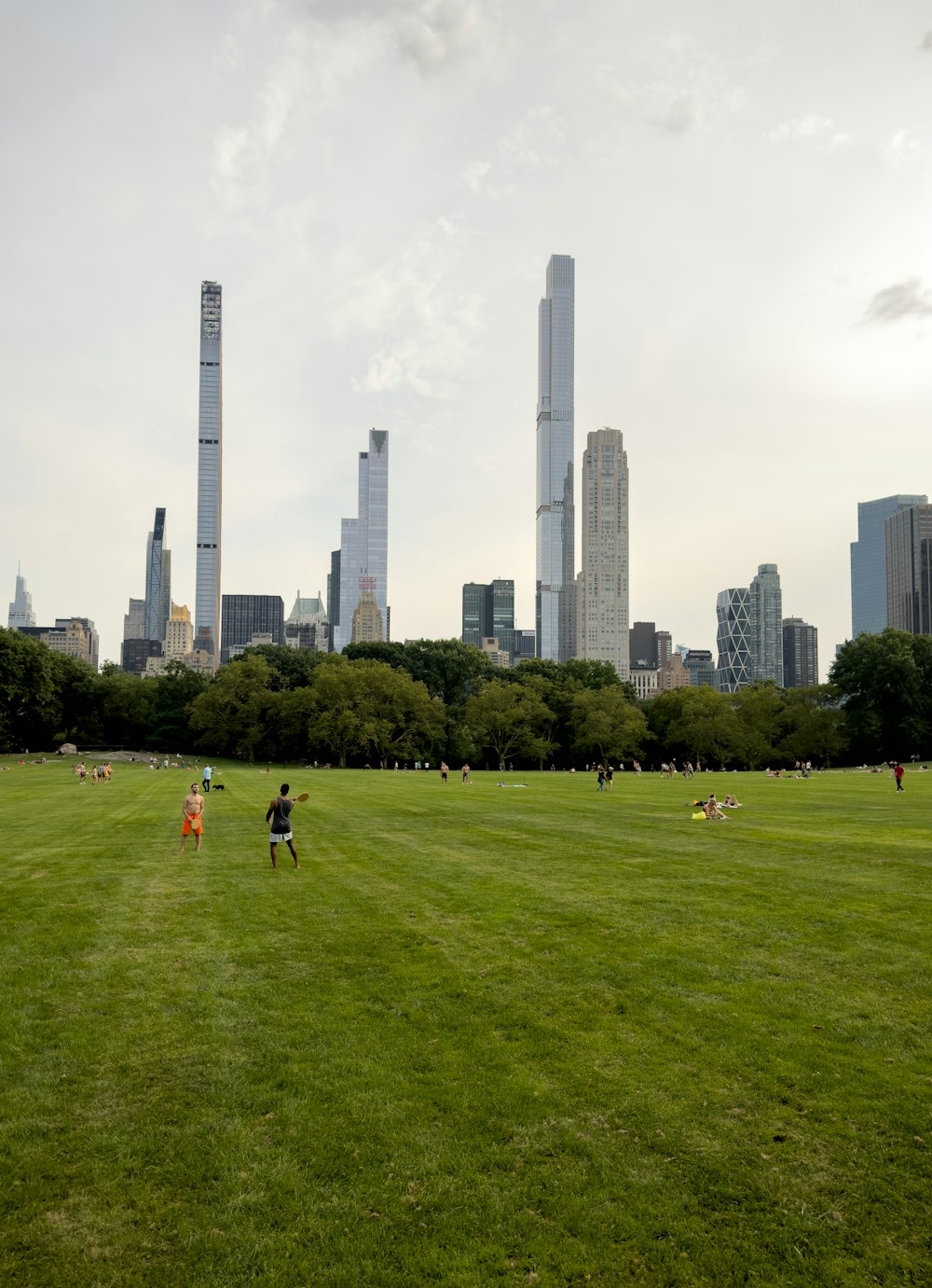 a group of people walking across a lush green field