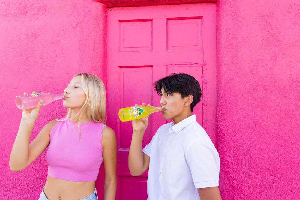 a man and a woman standing in front of a pink door