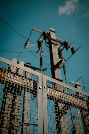 a close up of a metal gate with a sky background