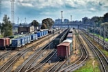 A lineup of various trucks ready for dispatch at a busy freight yard.