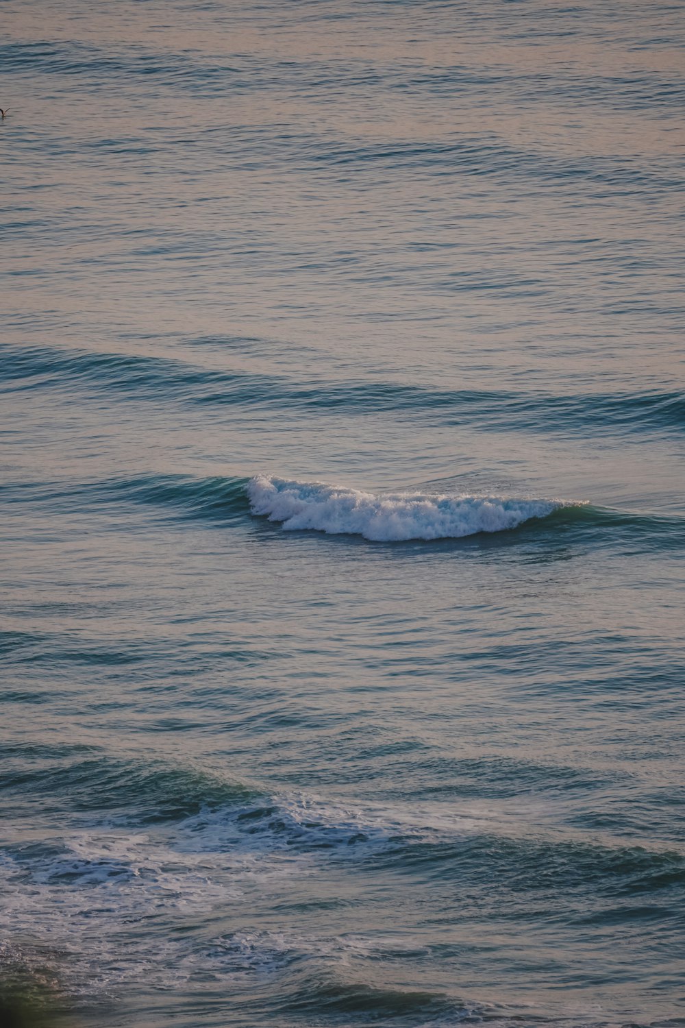 a person riding a surfboard on a wave in the ocean