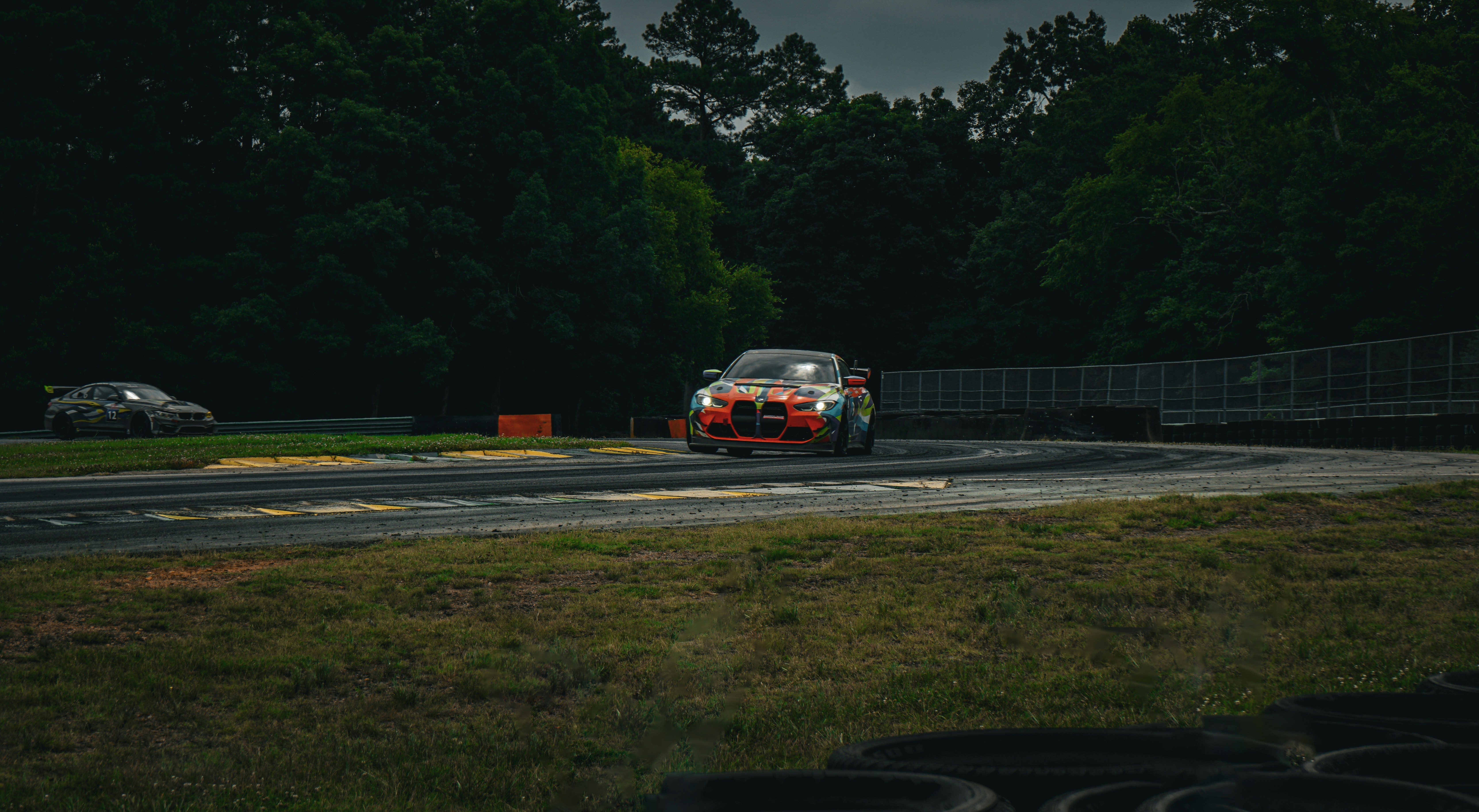 A car driving on a race track with trees in the background photo – Free ...