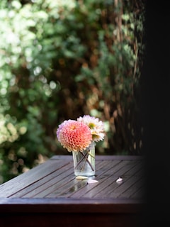 A vibrant bouquet of spring flowers in soft pastel tones, arranged elegantly on a rustic wooden table.