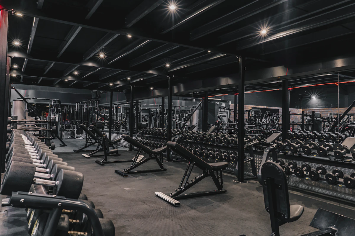 Wide shot of a fully equipped gym floor with machines, racks and dumbbells