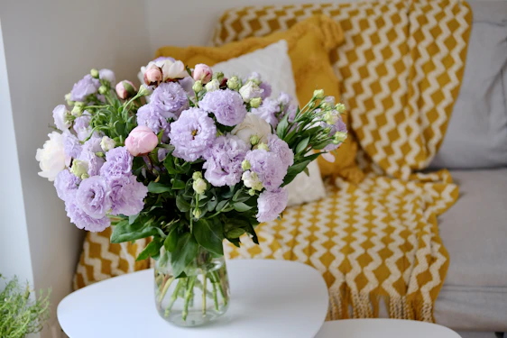 a vase filled with purple and white flowers on a table