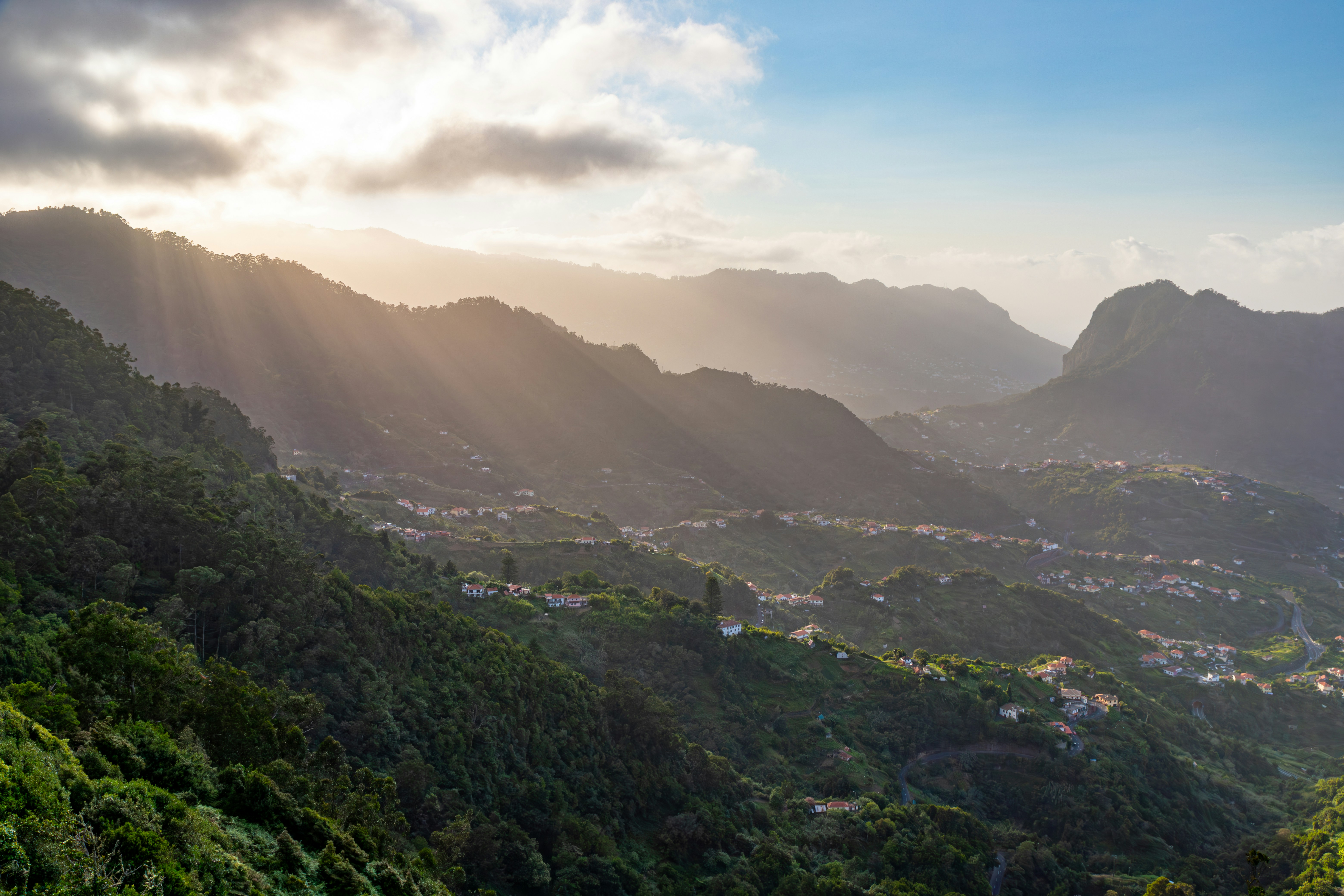the sun shines through the clouds over the mountains