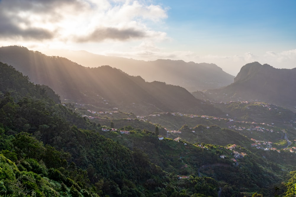 the sun shines through the clouds over the mountains