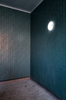 an empty room with a round light on the wall