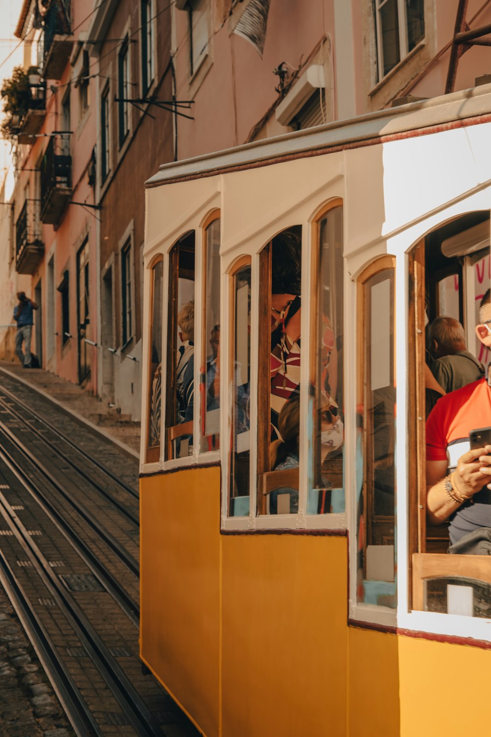 a yellow trolley car with people riding on it