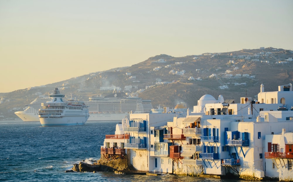 a cruise ship is in the background of a row of white buildings