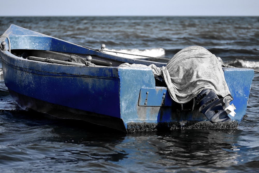 Un bote azul en el agua con una persona en él