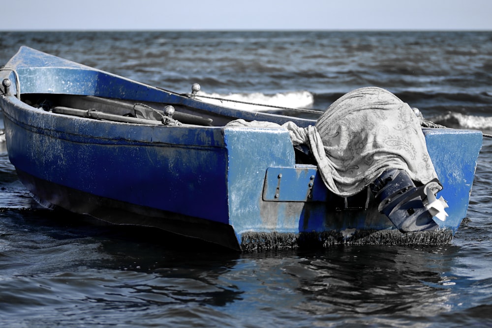 um barco azul na água com uma pessoa nele