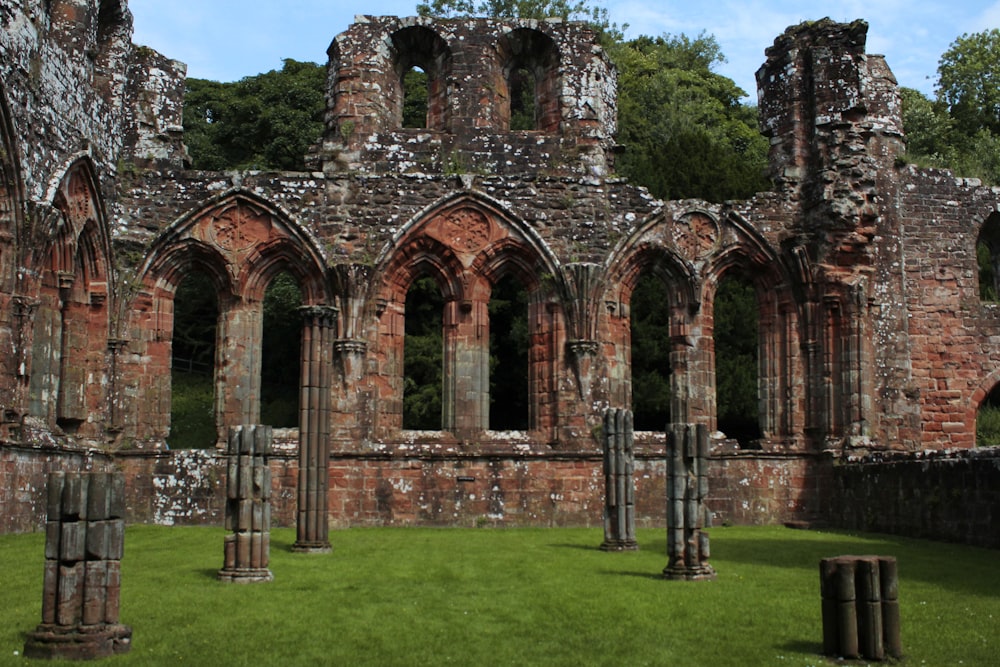 the ruins of an old church with grass in front of it