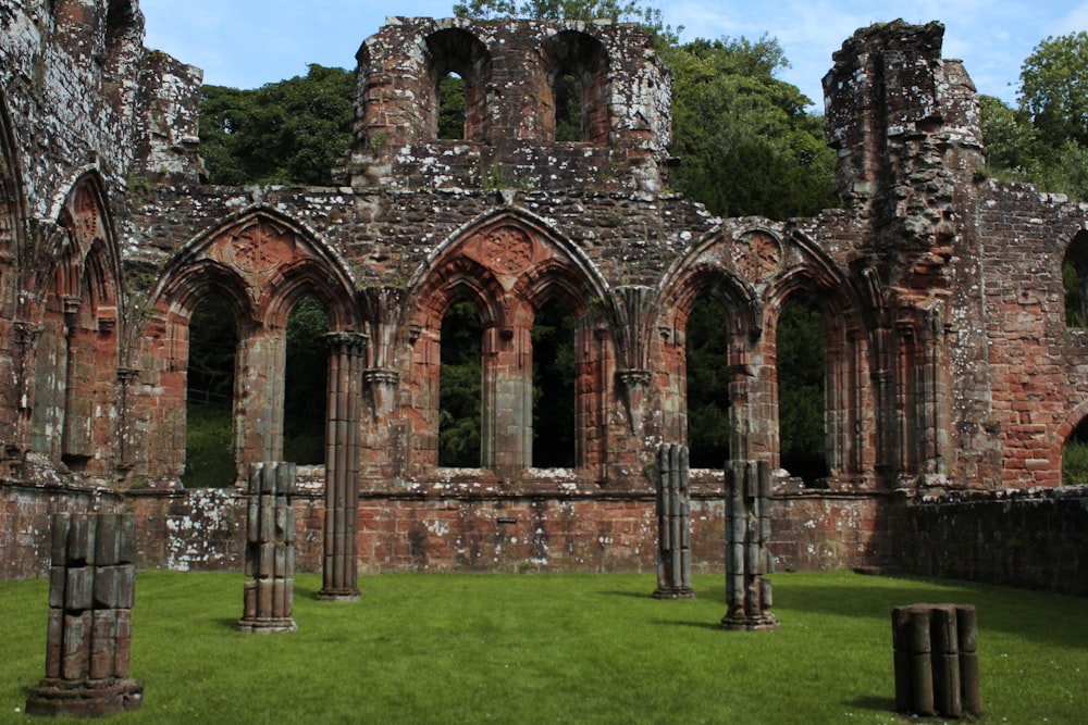 as ruínas de uma antiga igreja com grama em frente