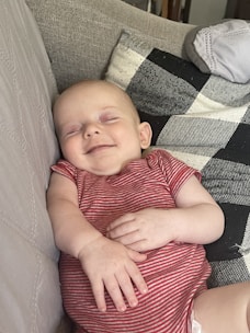 A smiling babysitter checking on a peacefully sleeping newborn in a cozy bedroom.