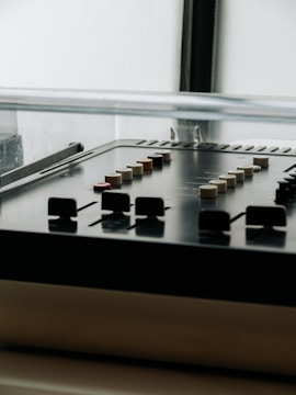 Close-up of a vintage analog mixing console with colorful knobs and sliders.