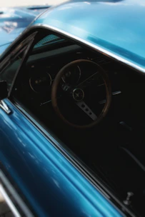 Close-up of a gleaming vintage car dashboard with polished wood and chrome details.