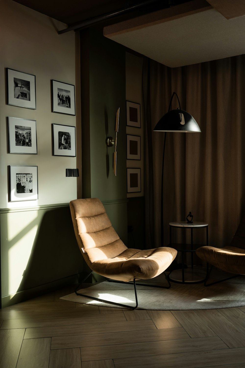 a living room with a chair and pictures on the wall