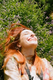 a woman laying in the grass with her eyes closed