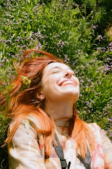 a woman laying in the grass with her eyes closed
